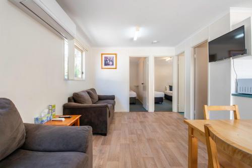 a living room with a couch and a table at Echo Holiday Parks - Windsor Gardens in Adelaide