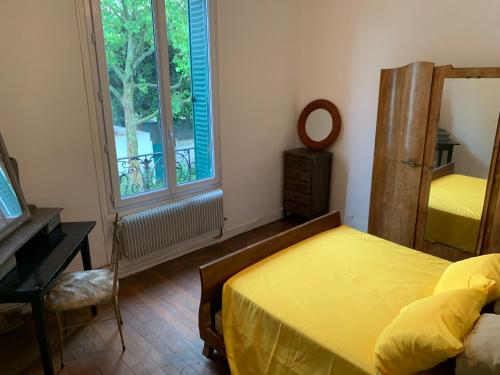 une chambre avec un lit, un miroir et une fenêtre dans l'établissement Pierre meulières, à Colombes