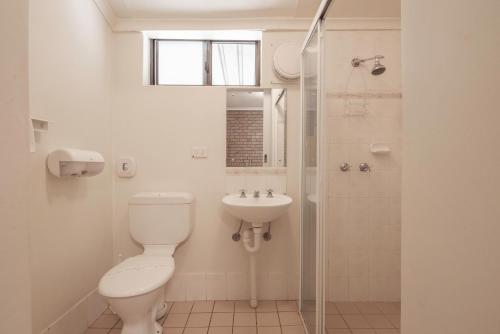 a white bathroom with a toilet and a sink at Echo Holiday Parks - Windsor Gardens in Adelaide