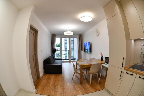 a kitchen and dining room with a table and a chair at Elegant Two-Room Apartment, Sleeps 4, Near Turon Arena, Balcony ,Air condition in Kraków