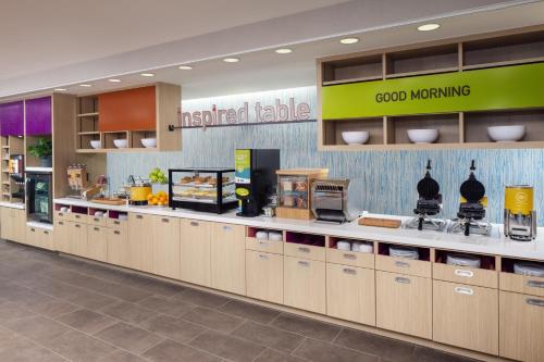 a fast food restaurant with a counter with food at Home2 Suites By Hilton Wilmington Medical Park Downtown in Wilmington