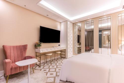 a bedroom with a bed and a desk and a television at Hotel The Designers Cheongnyangni in Seoul