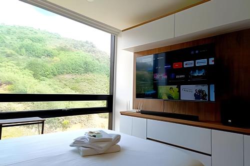 a room with a large window and a television at AH/Loft natural, Coworking, terraza+Gym, Usaquén in Bogotá