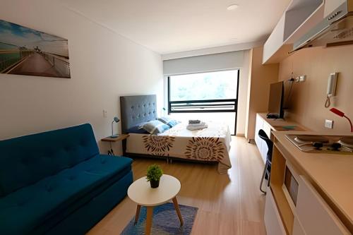 a small living room with a blue couch and a bed at AH/Loft vista natural, Coworking, Terraza, Usaquén in Bogotá