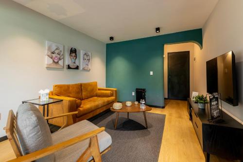 a living room with a couch and a table at Capitalia Condesa Escandon in Mexico City
