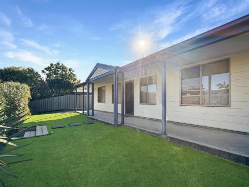 a house with a yard with green grass at Spacious 4-Bed Home 2-Min to the Beach in Broulee