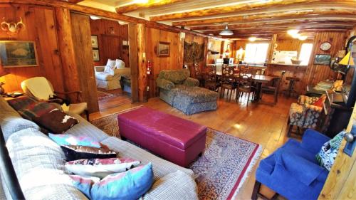 a living room with a couch and a dining room at Bear Run - Walk to Main Street - Rustic Cabin - WiFi - Washer - Dryer - Wood Burning Fireplace - Secluded Setting in Red River