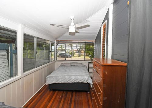 a bedroom with a bed and a dresser in a house at Crab Shack on Moreton in Toogoom