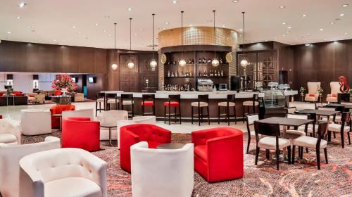 a restaurant with red and white chairs and a bar at Holiday Inn Bucaramanga Cacique by IHG in Bucaramanga