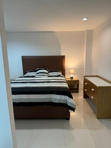 1 dormitorio con 1 cama en blanco y negro y mesita de noche en Hotel Margarita Real Penthouse 6403, en Porlamar