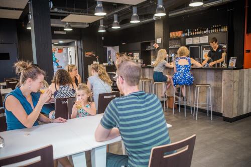 a group of people sitting at a table in a restaurant at De Draecke Hostel in Ghent
