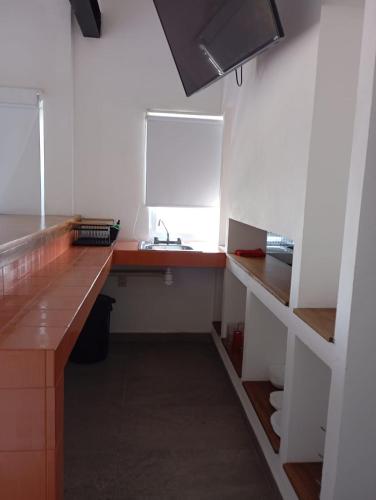 a kitchen with a counter and a sink in a room at Papaya Condo Acapulco Diamante -Solo Adultos in Acapulco