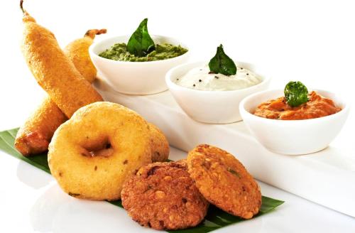 a plate of food with donuts and dip and dips at ITC Grand Chola, a Luxury Collection Hotel, Chennai in Chennai