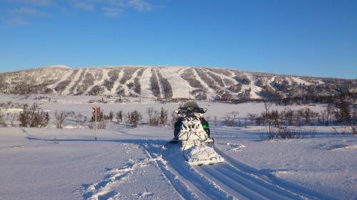 a person standing in the snow with a snowboard at Storliens Fjällgård in Storlien
