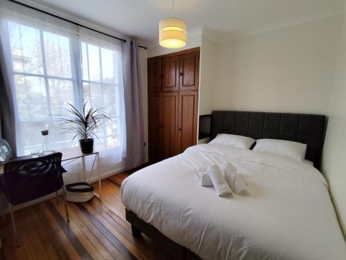Un dormitorio con una cama blanca con una ventana grande. en Casa CasCal, en Santiago