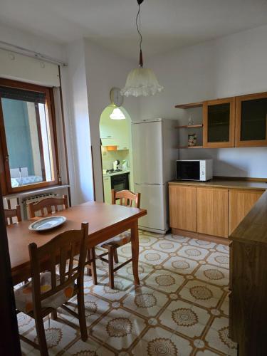 Una cocina con mesa y sillas y un refrigerador. en DI IORIO Apartment Termoli, en Termoli