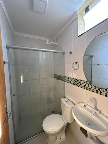 a bathroom with a toilet and a sink and a mirror at Hotel Nova Jerusalém in Goiânia