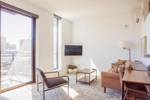 a living room with a couch and a table at Modern East Side 1BR Apt with Balcony, Pool, and Gym in Milwaukee