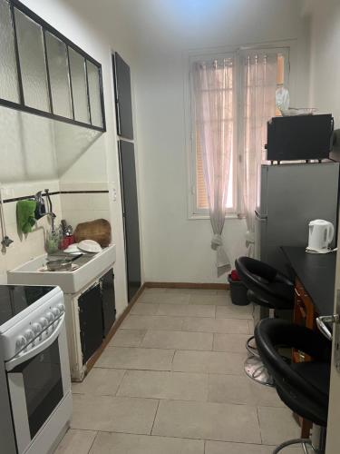 une petite cuisine avec un évier et un réfrigérateur dans l'établissement Appartement gare Nice ville, à Nice