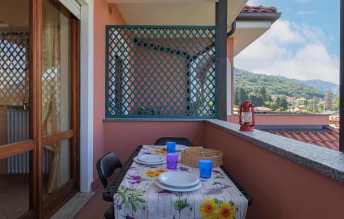 a table with plates on a balcony with a view at 2 Bedroom Beautiful Apartment In Stresa in Stresa