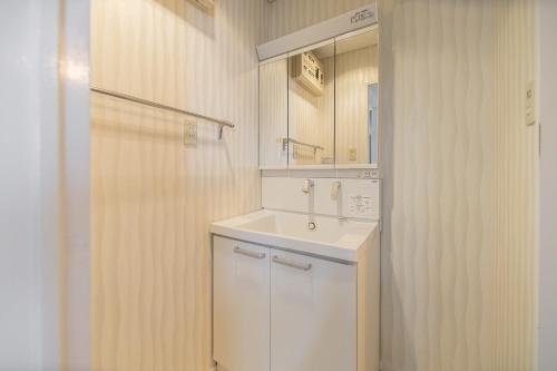 a white bathroom with a sink and a mirror at Z7全新装修套房3室2厅 新宿2站4分钟,Max 8p-spacious,3rooms Near Shinjuku in Tokyo