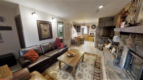 un soggiorno con divano in pelle e camino di Claim Jumper A-Frame 3 - WiFi - Cable - Hot Tub - Washer - Dryer - Wood Burning Fireplace a Red River