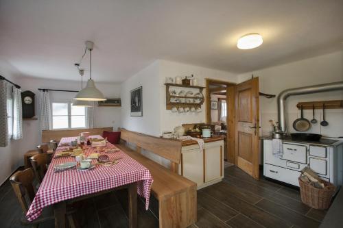 a kitchen with a table with a red and white checkered table cloth at Schwadenguetl in Gosau