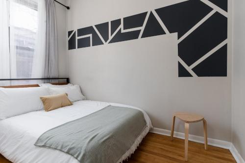a bedroom with a bed and a stool next to a window at Flexhome Ukrainian Village - 2BR - Convenient Walkability in Chicago