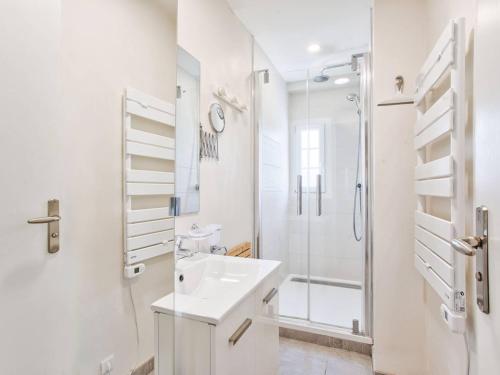 une salle de bain blanche avec un lavabo et une douche dans l'établissement Cocon lumineux pour 4 personnes à 200m de la plage - Merville Franceville - FR-1-788-18, à Merville-Franceville-Plage