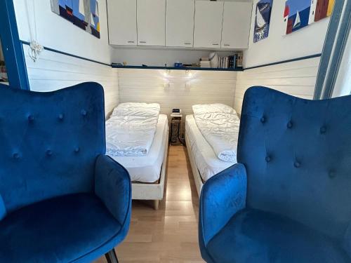 Cette petite chambre comprend deux lits et deux chaises. dans l'établissement Studio climatisé à 300m de la plage avec parking et terrasse - Argelès-sur-Mer - FR-1-732-84, à Argelès-sur-Mer