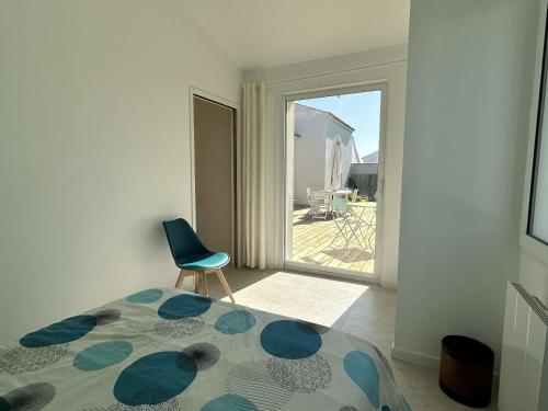 - une chambre avec un lit, une chaise et une porte coulissante en verre dans l'établissement Maison rénovée proche plage, terrasse privée, 4 chambres, 8 couchages, parking, WiFi - FR-1-224B-231, à Noirmoutier-en-l'lle