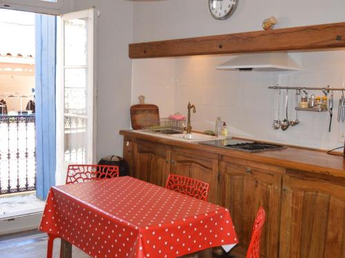 une cuisine avec une table et un chiffon rouge et blanc à la polka dans l'établissement Maison vigneronne rénovée, charme et sérénité, 3 chambres, garage, patio et terrasses, proche étang de Thau. - FR-1-604-52, à Loupian