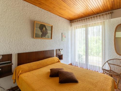 une chambre avec un lit jaune et une fenêtre dans l'établissement Maison Familiale au Milieu des Pins à Biscarrosse - 6 Pers, 300m du Lac, Ménage Inclus - FR-1-319-573, à Biscarrosse