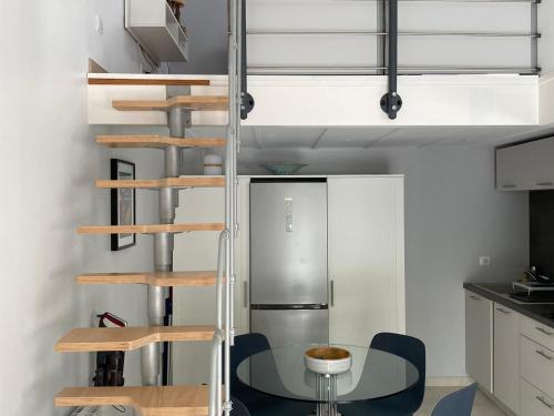 une cuisine avec une table et un réfrigérateur en métal dans l'établissement Maisonnette de Vacances à 200m de la Plage avec Terrasse à Saint-Georges-de-Didonne - FR-1-550-84, à Saint-Georges-de-Didonne