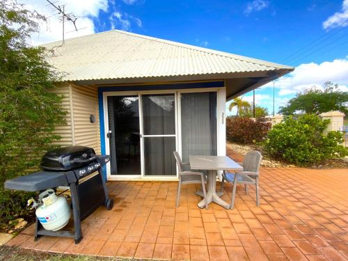 a patio with a grill and a table and chairs at Osprey Holiday Village Unit 222 1 Bedroom in Exmouth