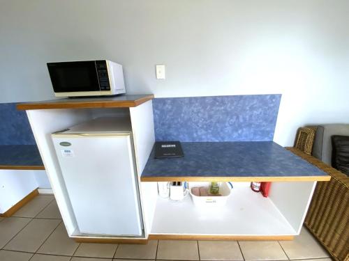 a counter with a microwave on top of a refrigerator at Osprey Holiday Village Unit 222 1 Bedroom in Exmouth