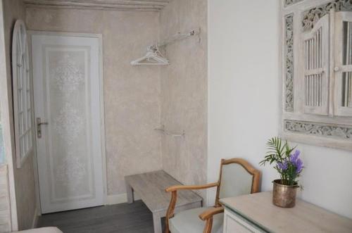 une chambre avec une table, une chaise et une porte dans l'établissement Petite chambre avec 2 lits dans maison d'artiste centre ville, à Bernay