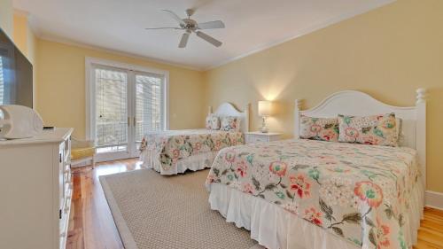 a bedroom with two beds and a ceiling fan at Tolater in DeBordieu Colony home by Peace Vacations in Georgetown