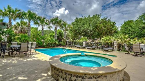 a swimming pool with a table and chairs next to anergynergynergyploadpload at Tolater in DeBordieu Colony home by Peace Vacations in Georgetown