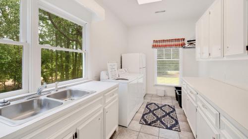 a white kitchen with a sink and a toilet at Tranquil by the Sea home by Peace Vacations in Georgetown