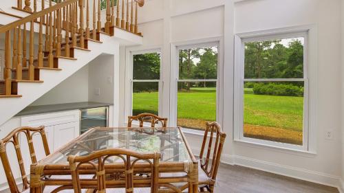 a dining room with a glass table and chairs at Tranquil by the Sea home by Peace Vacations in Georgetown
