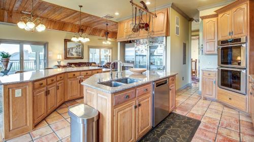 a large kitchen with wooden cabinets and a sink at Mull Cottage home by Peace Vacations in Georgetown