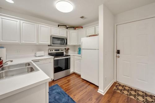 a kitchen with white cabinets and a white refrigerator at 52F True Blue Golf Getaway condo by Peace Vacations in Pawleys Island