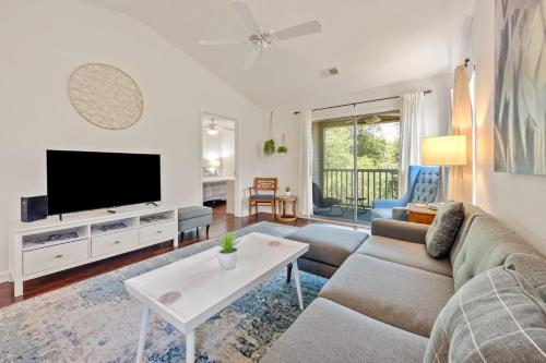 a living room with a couch and a tv at 52F True Blue Golf Getaway condo by Peace Vacations in Pawleys Island