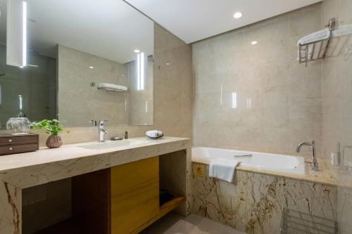 a bathroom with two sinks and a large mirror at Xinhua Media Hotel in Nanjing