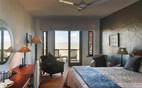 a bedroom with a bed and a table and chairs at Isandlwana Lodge in Hlazakazi