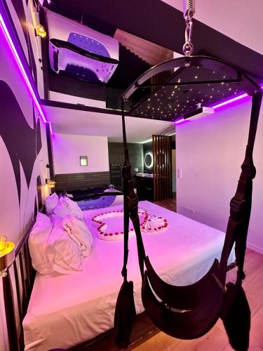 łóżko z hamakiem w pokoju z fioletowymi światłami w obiekcie La Belle Nuit suite Nuit Étoilée w mieście Saint-Gilles
