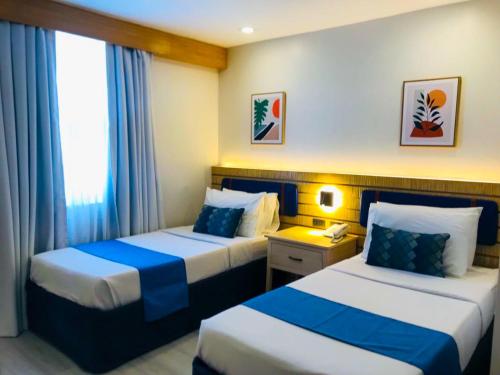 Postel nebo postele na pokoji v ubytování Cebu Uncle Tom's Cabin Hotel powered by Cocotel