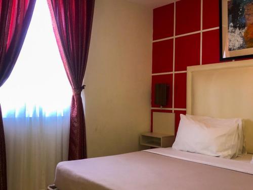 a bedroom with a bed and a window at Cebu Uncle Toms Cabin Hotel powered by Cocotel in Cebu City
