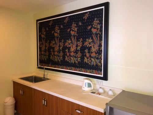 a tapestry hanging on a wall above a sink at Cebu Uncle Toms Cabin Hotel powered by Cocotel in Cebu City